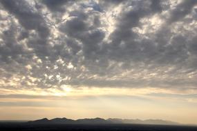 sunrise in gray clouds over mountains