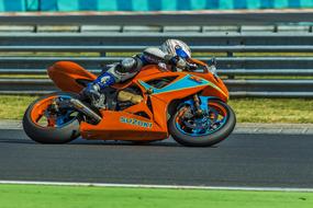 Person in equipment, on the colorful bike for motor racing, on the road, on the competition