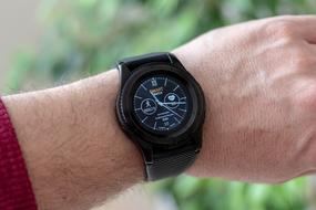 black wrist watch on hand on blurred background