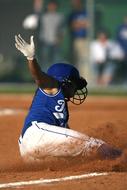 Softball girl player, in dirt, on the softball field, with white lines, with the spectators