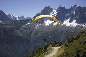 yellow paraglider over the alps