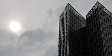 Black and white photo of the beautiful Dancing Towers, under the cloudy sky with light, on Reeperbahn, in Hamburg, Germany