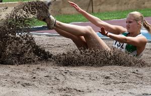 sportswoman jumping in the sand