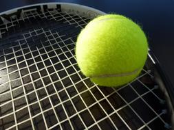 bright tennis ball on a racket close-up