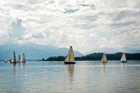 white clouds with sailboats on the lake