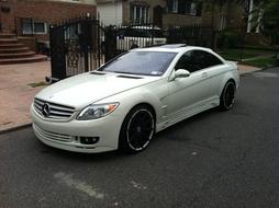 Beautiful, shiny, white "Mercedes Daimler" sport car on the street, near the buildings