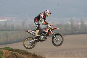 Person on the motocross competition, in jump, in Pulkau, Austria, near the colorful plants