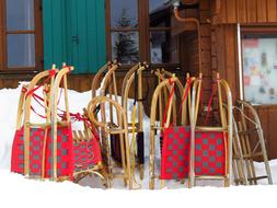 Close-up of the colorful and beautiful toboggan sleds, among the snow, near the hut, in the winter