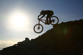 Silhouette of a person, riding on the beautiful mountain with rocks, in sunlight