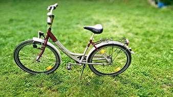 children's bike is parked on a green meadow