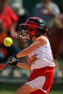 Softball girl player in white and red uniform, and in helmet