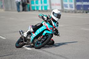 Biker on the beautiful turquoise and red bike, riding on the asphalt