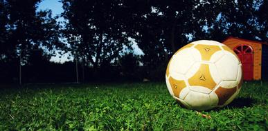 yellow-white soccer ball on the grass close-up