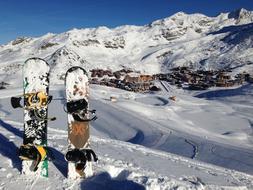 Colorful snowboards, standing on the beautiful, snowy mountains, in sunlight, at blue sky on background