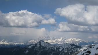 Beautiful panorama of the snowy Alpine mountains in Austria, at blue sky with white clouds on background