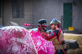 Man on the paintball game, in equipment, in light, near the buildings