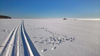 Skiing track, on the white snow, at blue sky on background, on the beautiful landscape, in winter