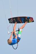 Blonde man, doing kite surfing on the colorful board