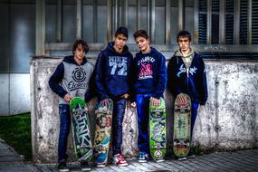 boys with skateboards stand near an abandoned building