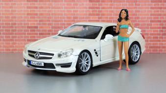 Model of the girl, in underwear, near the model of the shiny, white "Mercedes Sl 65 Amg" car, near the brick wall