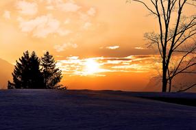 sunrise in the clouds over a snowy landscape