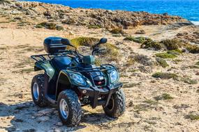 Shiny buggy vehicle, on the shore, with the beautiful blue water