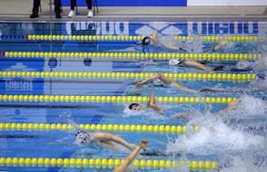 People, swimming in the blue swimming pool, with reflections