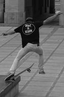 black and white photo of a man doing a trick on a skateboard