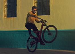 guy on a bike near the house at dusk