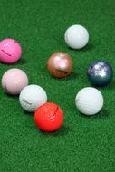 Close-up of the colorful, glossy golf balls, on the green grass