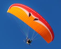 Paraglider, on the colorful motor glider, in the beautiful, blue sky