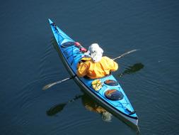 Kayaking, person in blue boat on calm water