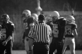 referee and soccer team on the field in black and white blurred background