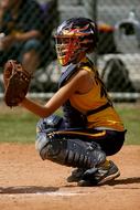 Softball female player, with the equipment, on the colorful field, near the fence