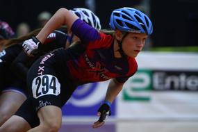 People in the colorful equipment, doing inline speed skating, on the competition