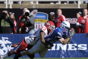 American football players in the colorful uniform, on the competition, with spectators