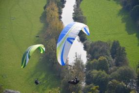 paragliders fly over the river in france