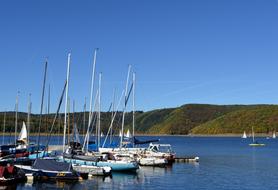 Boats, on the beautiful lake in Rurtalsperre Schwammenauel, near the beautiful and colorful hills, in Germany