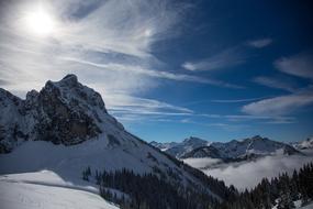 Beautiful, snowy mountains with trees, in light and shadow, in Bavaria, Germany