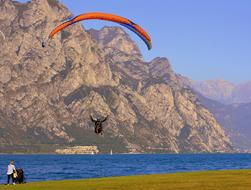 People, doing paragliding, above the beautiful Garda Lake and colorful mountains in Italy