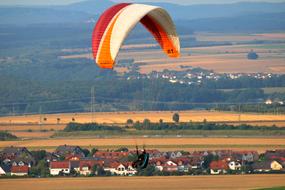 Paraglider Flying over rural Landscape