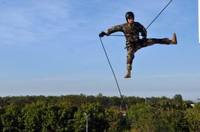 a man descends a rope from a cliff