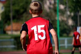 Boy player with number "15" on the field, on the football conmpetition