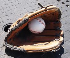 baseball glove with ball on the sidewalk