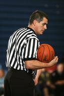 Basketball, with the striped, orange and black basketball ball in the hand, on the competition