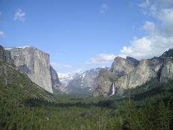 Beautiful landscape of the Yosemite National Park with the green trees, among the mountains, under the blue sky with white clouds, in California, USA