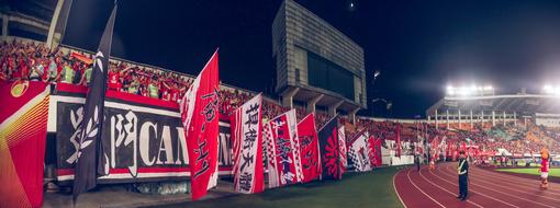 many flags in the stadium with spectators