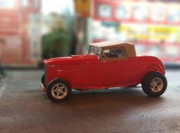 mini model of a classic red car on a blurred background
