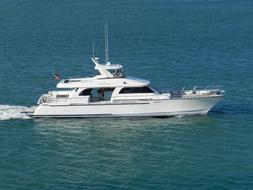 White boat on the beautiful, turquoise and blue water with ripple, in sunlight