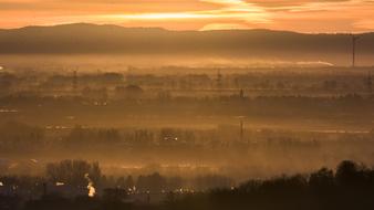 Beautiful landscape with the plants in fog, among the mountains, under the colorful and beautiful sunrise with clouds